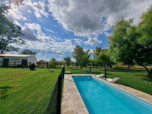 una piscina en un patio con una valla en Casa de campo en Zapiola , Lobos, Buenos Aires. en Lobos