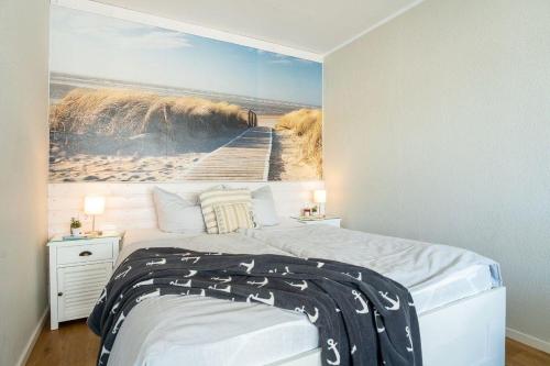 een slaapkamer met een bed met een schilderij aan de muur bij Haus-Steinwarder-7-Wohnung-Strandbude-17 in Heiligenhafen