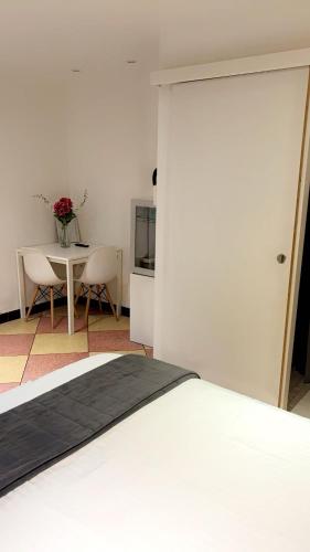 a bedroom with a white bed and a table and a tableablish at Chambre Olivier in Arles