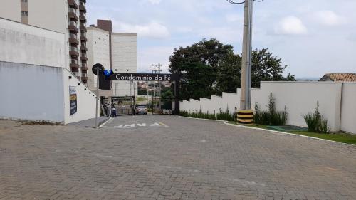 een lege parkeerplaats met een bord voor een gebouw bij Apartamento com Garagem no Condomínio da Fé, Pertinho da Canção Nova, Cachoeira Paulista SP in Cachoeira Paulista