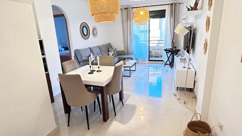 een eetkamer en een woonkamer met een tafel en stoelen bij Ático Calas de Nerja in Nerja