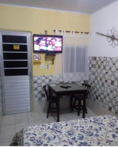 a bedroom with a table and a tv on the wall at Pousada em Fazenda Nova Dona Rosy in Fazenda Nova