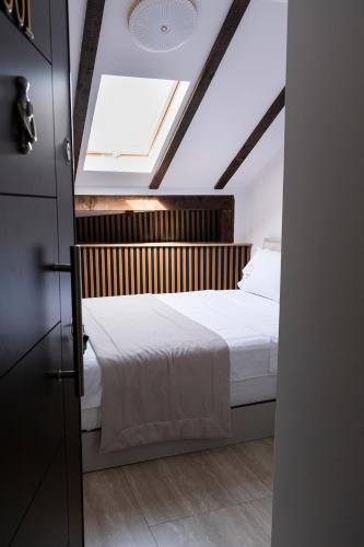 a bedroom with a bed with a skylight at Treva Hotel & Apartaments in Prizren