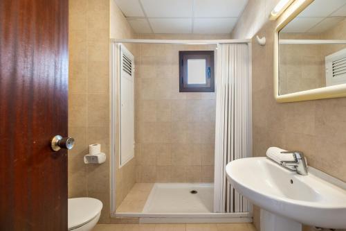 ein Bad mit einer Dusche, einem Waschbecken und einem WC in der Unterkunft Apartamento Bilo 301 in Es Pujols