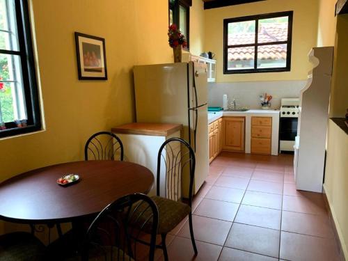 a kitchen with a table and a refrigerator at Villas JABEL TINAMIT in Panajachel