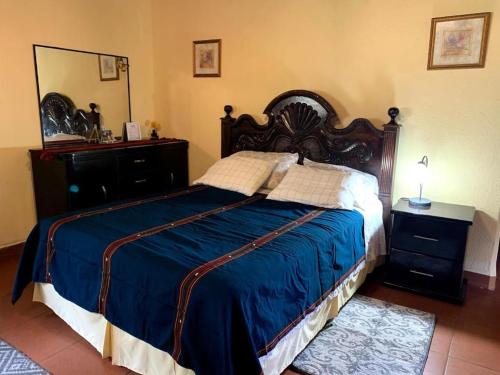 a bedroom with a large bed with a blue blanket at Villas JABEL TINAMIT in Panajachel