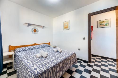 ein Schlafzimmer mit einem Bett und einem karierten Boden in der Unterkunft Apartamento Bilo 301 in Es Pujols