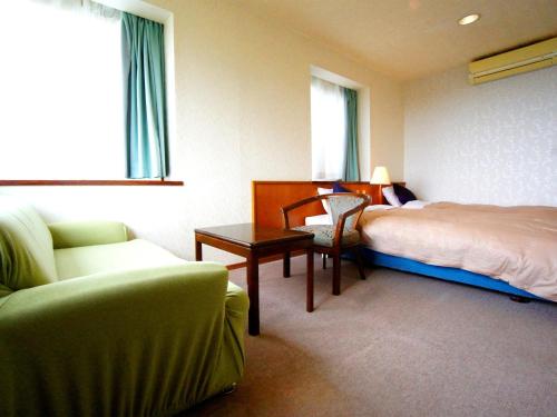 una camera con letto, tavolo e sedia di We Home Villa - Jogasaki Onsen - - Vacation STAY 13634v a Ito