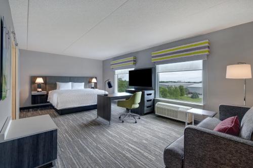 バーリントンにあるHampton Inn & Suites Burlington, Ontario, Canadaのベッドとデスクが備わるホテルルームです。