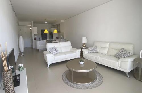 una sala de estar con 2 sofás blancos y una mesa. en Luxury apartment in Higuerón - Serenity en Málaga