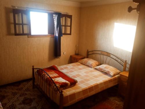 Un dormitorio con una cama con una manta. en Sweaty house en Esauira