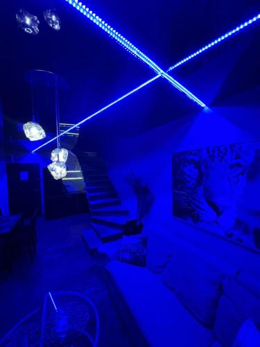 a living room with blue lights and a couch at EGZOTYCZNO - ROMANTYCZNE miejsce dla DWOJGA in Ełk