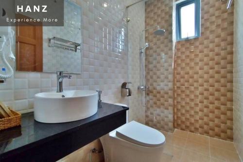 uma casa de banho com um lavatório, um chuveiro e um WC. em HANZ Hoa Dang Hotel em Da Lat