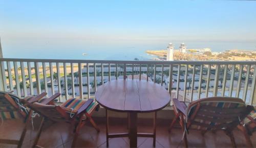 una mesa y sillas en un balcón con vistas al océano en Porto Sokhna Pyramids Apartments, en Ain Sokhna