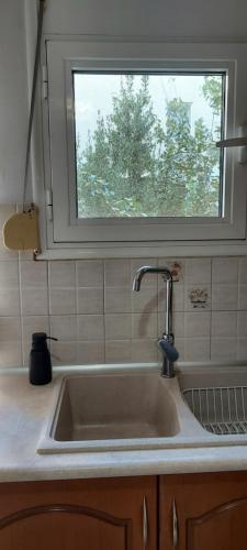 un fregadero en una cocina con una ventana encima en Like your home en Komotini