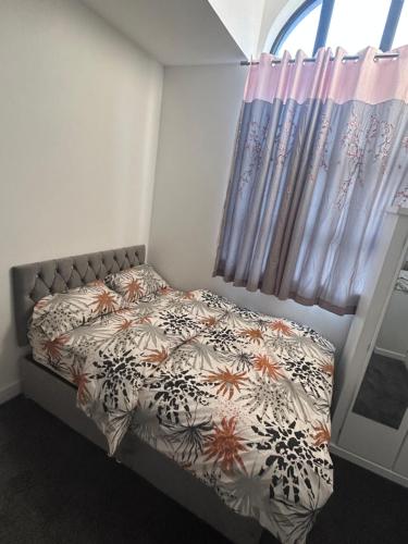 曼徹斯特的住宿－Lovely 1 bed apartment in Salford，一间卧室配有一张带床罩的床和窗户