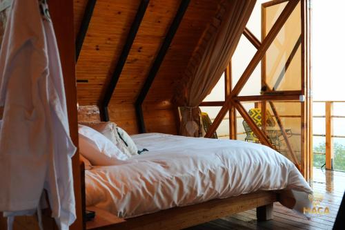 a bed in a room with a wooden ceiling at MACA GLAMPING in Calima