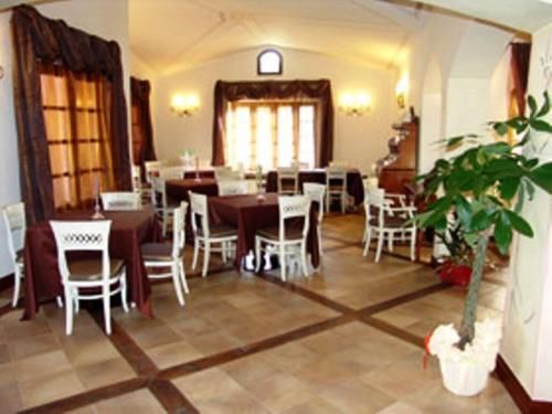 a restaurant with tables and chairs and a potted plant at Tenuta Le Terre 1927 in San Teodoro