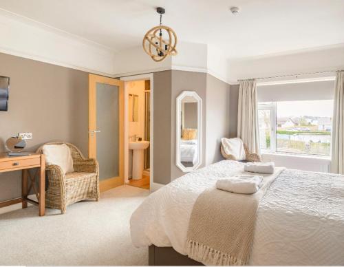a bedroom with a bed and a desk and a window at Larkhill House in Portrush