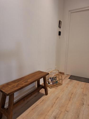 um banco de madeira num quarto vazio com uma cesta em Chambre avec salle d'eau privée em Agen