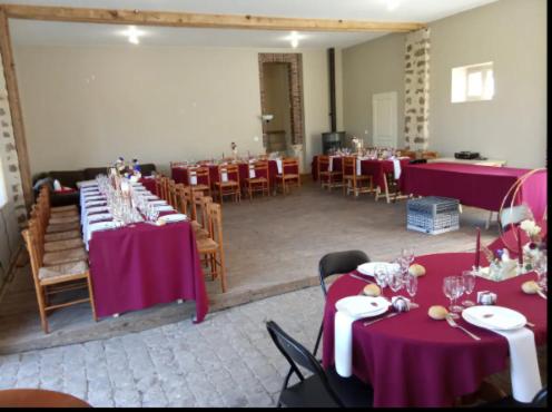 ein Zimmer mit Tischen und Stühlen mit lila Tischdecken in der Unterkunft Domaine du Parc et Château de Manou in Manou