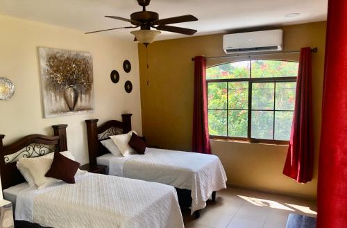 a room with two beds and a window at Habitación Hermosa a 3 cuadras del Parque de Copán in Copan Ruinas