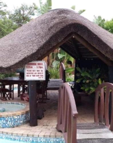a hut with a sign in front of a pool at Fish Eagle Manor in East London