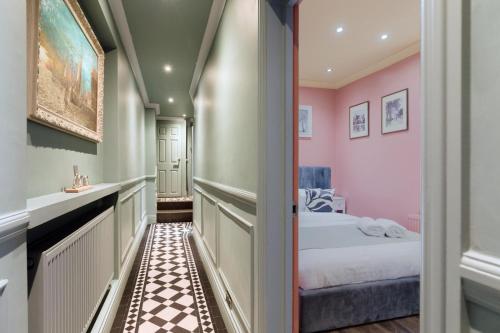 niewielka sypialnia z różowymi ścianami i łóżkiem w obiekcie Stylish 2 Bedroom Flat, Sleep 6 & Garden London Zone 2 cls Central w Londynie