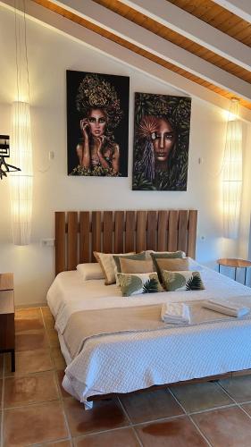 a bedroom with a large bed with two pictures on the wall at Villa JAP in Benidorm