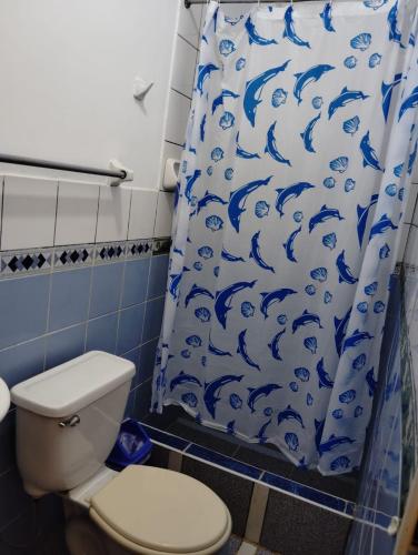 ein Badezimmer mit einem blauen Duschvorhang und einem WC in der Unterkunft El Tritón in Máncora