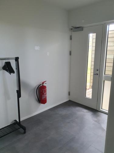 a white room with a fire hydrant next to a door at Skógar Lodge in Hvolsvöllur