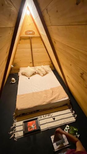 a bed in a tent with a stack of books at A Chave da Montanha 