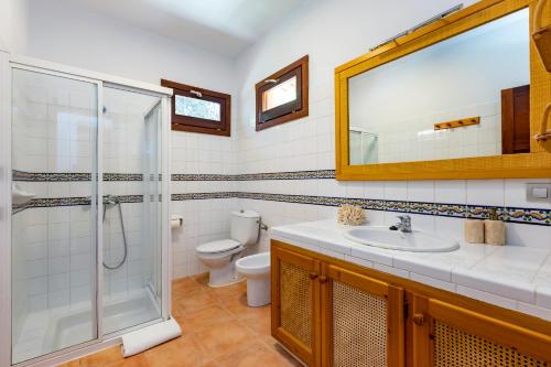 y baño con aseo, lavabo y ducha. en Villa in San Rafael Sleeps 12, en Ses Paisses