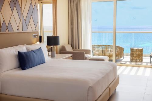 a hotel room with a large bed and a large window at Royalton Splash Riviera Cancun, An Autograph Collection All-Inclusive Resort in Cancún