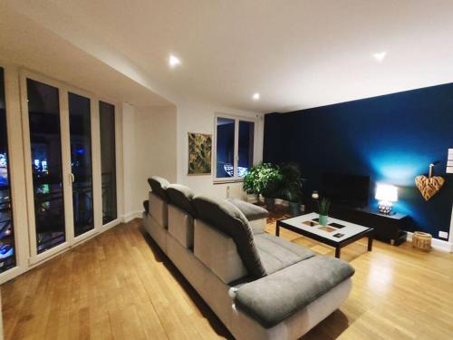 un soggiorno con divano e tavolo di Appartement spacieux a Charmes