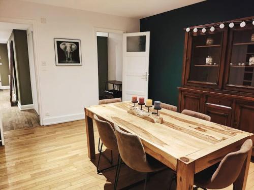 una sala da pranzo con tavolo e sedie in legno di Appartement spacieux a Charmes