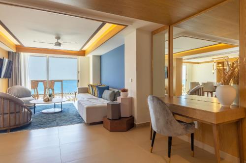 a living room with a table and a couch at Royalton Splash Riviera Cancun, An Autograph Collection All-Inclusive Resort in Cancún