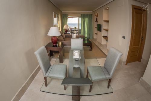 Una sala de estar con una mesa de cristal y sillas. en Balcón del Puerto, Ático-Solarium, en Tazacorte