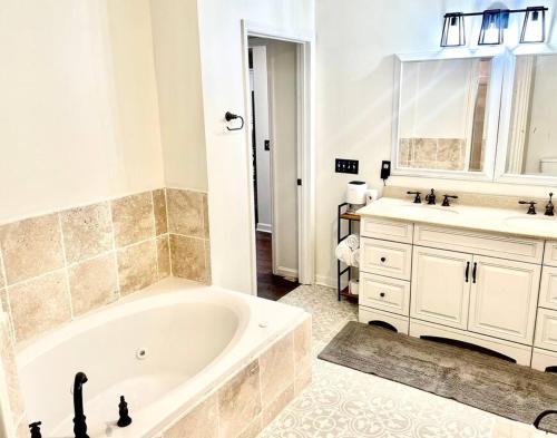 ein Badezimmer mit einer Badewanne, einem Waschbecken und einer Badewanne in der Unterkunft Historic Cottage in Five Points near Downtown in Huntsville