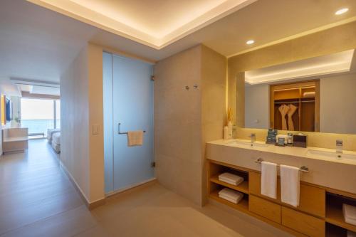 a bathroom with a sink and a mirror at Royalton Splash Riviera Cancun, An Autograph Collection All-Inclusive Resort in Cancún