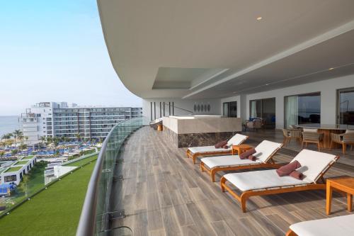 a balcony with lounge chairs and tables on a building at Royalton Splash Riviera Cancun, An Autograph Collection All-Inclusive Resort in Cancún
