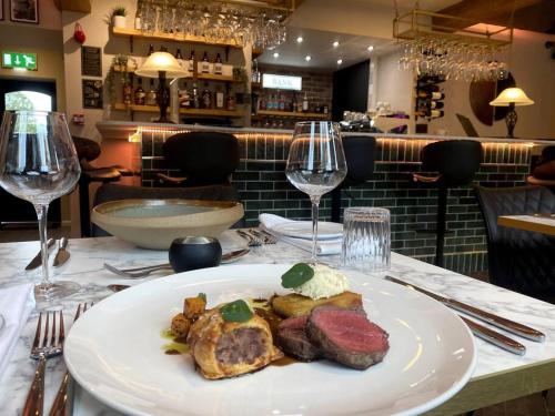 a plate of food on a table with wine glasses at The Bankers Quarters - Apt 2 in Chapel en le Frith