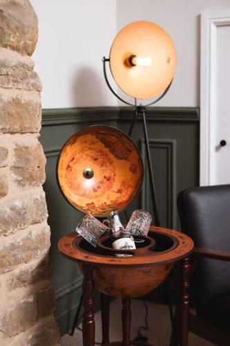 a lamp on a table next to a wall at The Bankers Quarters - Apt 2 in Chapel en le Frith