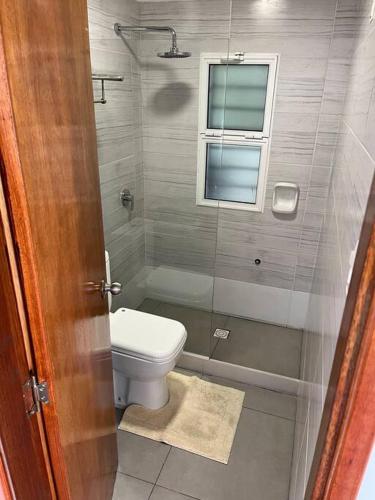 a bathroom with a toilet and a window at Casa moderna recien terminada in Maldonado