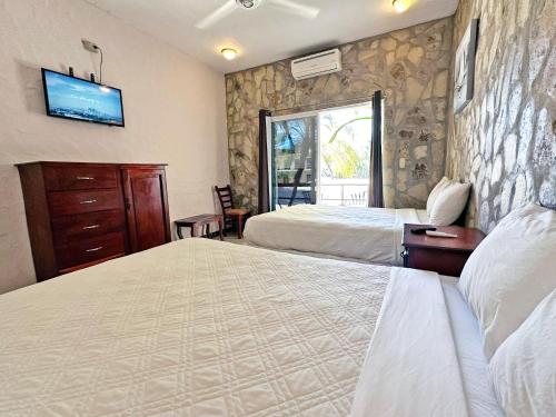 a hotel room with two beds and a tv on the wall at Surf Ranch Hotel & Resort in San Juan del Sur