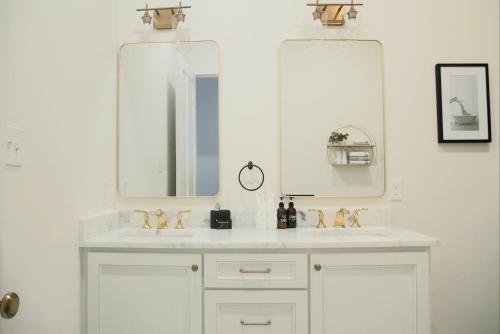 a bathroom with two sinks and two mirrors at Entire Spacious Vacation Home - Close to all City Attractions in New Orleans
