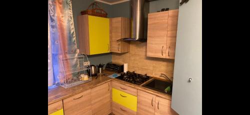 a kitchen with wooden cabinets and a yellow kitchen at Leśna Polana- Kompleks Domków Mieszkalnych 