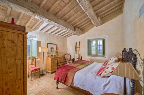 - une chambre avec un lit et une chaise dans l'établissement Podere San Bernardino, à San Casciano dei Bagni