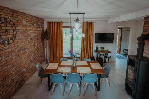 a dining room with a wooden table and blue chairs at Gościniec Chlebowy Zakątek 