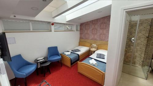 ein kleines Zimmer mit 2 Betten und einer Dusche in der Unterkunft OÁZIS Hotel*** in Nagykanizsa